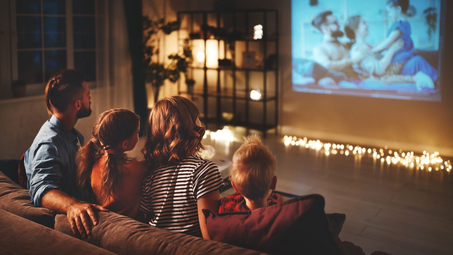A Family Sitting on a Sofa Watching a Movie